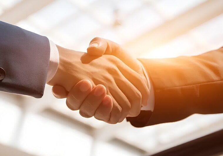 Two people shaking hands in a room.